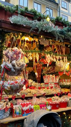 a man is standing in front of a christmas market with lots of candy and candies