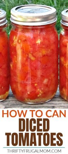 four jars filled with diced tomatoes sitting on top of a wooden table next to green grass