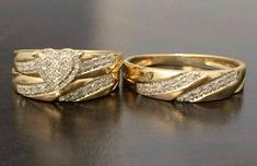 two gold wedding rings sitting on top of a table