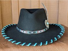 The Twilight felt hat is 100% wool and has a 3.5" brim and 4.25" crown. Hand laced in black and turquoise leather lace. The black leather band features hitched webbing. Decorative large turquoise Concho and Guinea feather completes the hat. Note: All hats are made to order. Please allow up to 4 weeks for your hat to ship. Black Felt Hat With Flat Crown For Ranch, Custom Black Fedora For Rodeo, Custom Black Brimmed Felt Hat, Southwestern Black Hat Bands For Country Events, Southwestern Black Hat With Short Brim, Black Felt Hat With Flat Crown For Country Events, Custom Fitted Black Hat Bands, Custom Black Hat Bands For Ranch, Custom Black Felt Hat For Western-themed Events