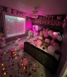 a bedroom decorated with balloons and confetti on the floor, pink lights in the window