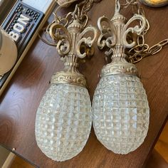 two glass lamps sitting on top of a wooden table