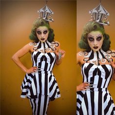 a woman with green hair and makeup is wearing a black and white striped dress while standing in front of a yellow wall