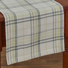 a plaid table runner on top of a wooden table