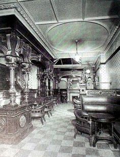 an old photo of a fancy restaurant with checkered flooring and chandeliers