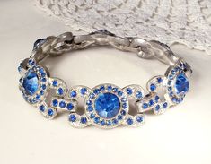 "Offering an absolutely exquisite 1930s era high quality Art Deco Old Hollywood Glam sapphire blue sparkly crystal rhinestone statement Flapper bracelet. The perfect \"Something Old\" and \"Something Blue\" for the Bride or with a pair of jeans and a tee! The well bracelet features ornate silver pot metal links pave set with rich sparkly sapphire blue crystal rhinestones. Photos don't even begin to do this bracelet justice or capture the incredible sparkle adequately. Bracelet closes with a hidd Adjustable Silver Jewelry For Vintage Events, Victorian Jeweled Wedding Bracelets, Antique Silver Round Bracelet For Wedding, Antique Silver Round Bracelets For Wedding, Vintage Antique Silver Bracelet For Wedding, Victorian Style Silver Party Bracelets, Victorian Antique Silver Bracelets For Wedding, Vintage Silver Jeweled Bracelets, Antique Silver Filigree Bracelets For Wedding