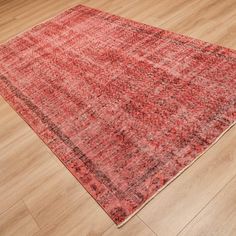 a large red rug is on the floor in an empty room with wood floors and hard wood flooring