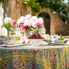 the table is set with flowers and wine for two people to enjoy in the sun