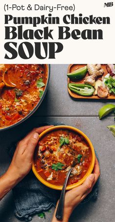 a person holding a bowl of soup with the title pumpkin chicken black bean soup