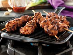 several skewered meats are being cooked on a grill