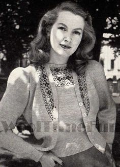 an old black and white photo of a woman in a sweater posing for the camera