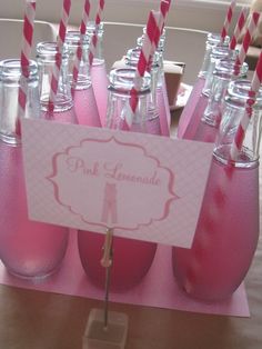 there are many pink soda bottles with straws in them