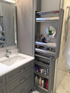 a bathroom with gray cabinets and white counter tops