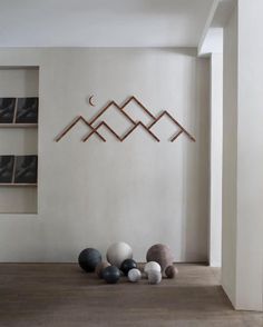 some balls are on the floor in front of a white wall and shelves with pictures