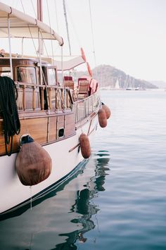 a sailboat is docked in the water with its mooring ropes hanging from it's sides