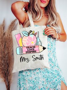 a woman holding a tote bag that says teach inspire, mrs smith