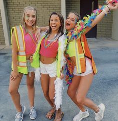 three young women dressed in bright clothing posing for the camera with their arms around each other