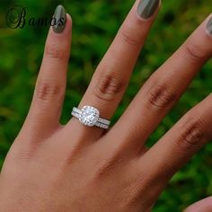 a woman's hand with a diamond ring on her finger and manicured nails