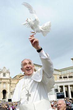 a man holding up a white dove in front of a building with words that read, i don't always visit the united states but when i do the devil can go to hell