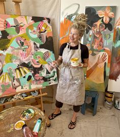 a woman in an art studio holding a cup