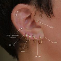 an ear with four different types of piercings on the top and bottom of it