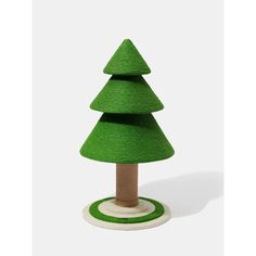 a small green christmas tree sitting on top of a white base with a wooden base