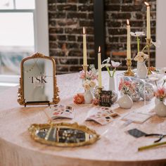 a table topped with lots of different items on top of a wooden table covered in flowers and candles