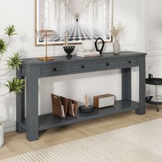 a grey console table with two drawers and books on it in front of a white wall