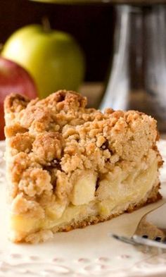 a close up of a slice of pie on a plate with an apple in the background