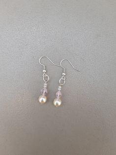 Silver drop-length earrings featuring cream pearl beads, pink transparent diamond-shaped beads and clear seed beads. These pretty earrings would look beautiful on a bride along with the matching bracelet.  Drop length measurement is the whole length including the ear wire. Delicate Silver Jewelry With Dangling Beads, Elegant Sterling Silver Beaded Earrings For Wedding, Elegant White Beaded Sterling Silver Earrings, Elegant Cream Jewelry With Dangling Beads, Elegant Round Beads Crystal Earrings For Wedding, Pearl Beaded Earrings With Ear Wire For Wedding, Pearl Earrings With Dangling Round Beads For Wedding, Pearl Drop Beaded Earrings For Wedding, Delicate Cream Jewelry With Pearl Drop