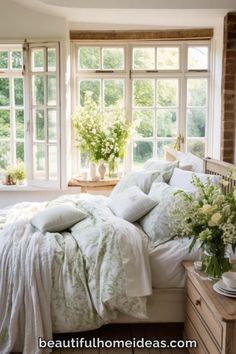 a bed with white comforter and pillows in front of two windows next to each other