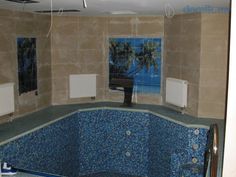 an empty swimming pool with tiled walls and blue tiles on the bottom floor, next to a heater