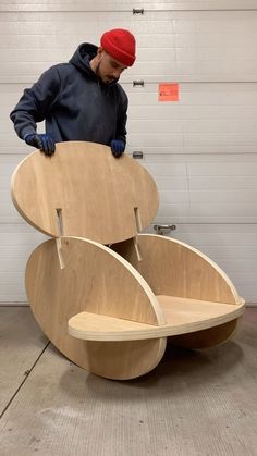 a man standing next to a large wooden object