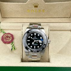 This timepiece is a Rolex GMT-Master II, a renowned model celebrated for its dual time-zone functionality and robust design. Its black dial with luminous markers ensures easy readability, complemented by a black Cerachrom ceramic bezel with a 24-hour scale. The watch features the classic Oyster bracelet in stainless steel, providing durability and comfort. Powered by either the Caliber 3186 or 3285, this watch guarantees exceptional precision and a power reserve of up to 70 hour. Luxury Black Diamond Watch With Diamond Hour Markers, Designer Black Diamond Watch With Diamond Hour Markers, Classic Black Automatic Diamond Watch, Black Diamond Watch With Diamond Hour Markers, Black Diamond Watch With Round Dial, Luxury Black Diamond Watch With Tachymeter, Black Automatic Business Watches, Luxury Black Chronograph Watch With Tachymeter, Black Diamond Watch With Chronograph