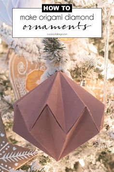 an origami ornament hanging from a christmas tree with text overlay reading how to make origami diamond ornaments