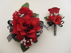 two red roses are placed next to each other on a white surface with black ribbon