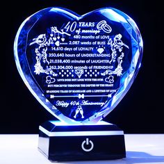 a blue heart shaped glass award with the date and time on it's side