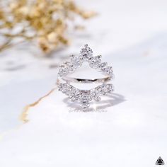 a diamond ring sitting on top of a table next to some dried flowers and branches