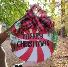 a woman holding up a merry christmas sign