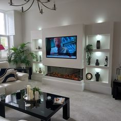 a living room filled with furniture and a flat screen tv mounted on the wall above a fireplace