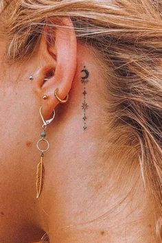 a woman's ear has a small tattoo on it