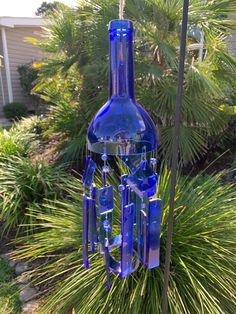 a blue glass bottle wind chime hanging from a pole