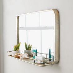 a bathroom mirror sitting on top of a shelf