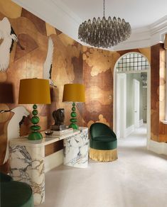 a living room filled with lots of furniture next to a wall covered in gold and green paint