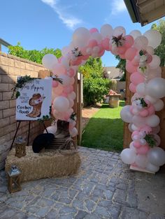 a pink and white balloon arch is set up outside