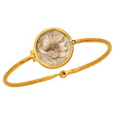 Length: 7" approx. Diameter: 60mm Band width: 2mm Weight: 11.80 grams (1) .01 CT natural, round diamond 21mm round replica coin Hook style clasp 925 sterling silver purity with 24KT gold plating The Sterling Silver and 24 Karat Gold Plated Replica Roman Coin Bangle Bracelet is a luxurious and elegant piece of jewelry that pays homage to ancient Roman culture and artistry. This stunning bangle bracelet combines two high-quality materials, sterling silver and 24 karat gold plating, to create a tim Elegant Adjustable Jewelry With Coin Pendant, Elegant Adjustable Coin Pendant Jewelry, Elegant Adjustable Coin-shaped Jewelry, Elegant Adjustable Coin Jewelry, Collectible Round Coin Pendant Jewelry, Luxury Collectible Round Bangle, Elegant Coin Shaped Metal Jewelry, Adjustable Tarnish Resistant Bangle, Tarnish Resistant Timeless Round Bangle