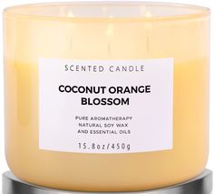 a candle that is in front of a white background with the words coconut orange blossom on it