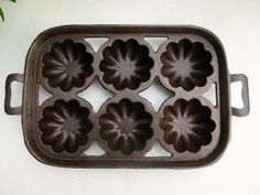 an old cast iron muffin pan with four flower shaped trays on the bottom