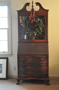 an old dresser has a wreath on top