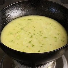 a pan filled with soup sitting on top of a stove